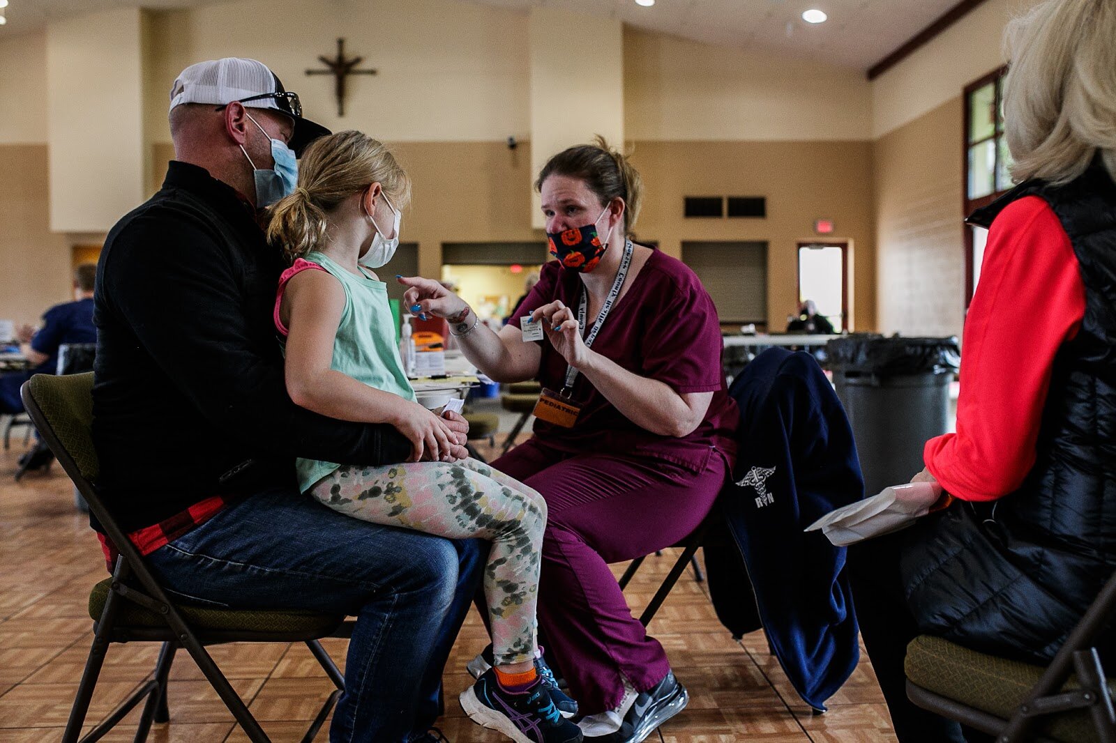 Genesee County Health Department Registered Nurse Elizabeth Jones provides instructions prior to administering Marin Derwin's (age 6) first Pfizer COVID-19 vaccine.