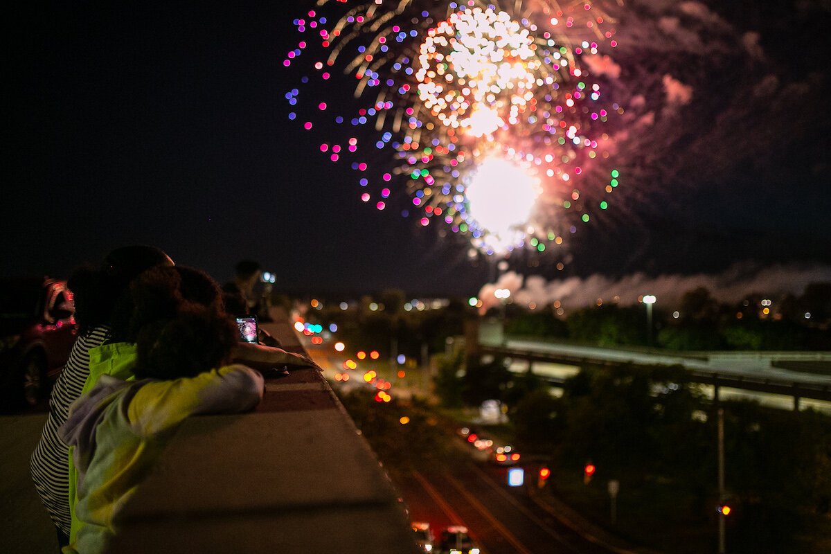 Spectators watch fireworks over the Flint River on Juneteenth.