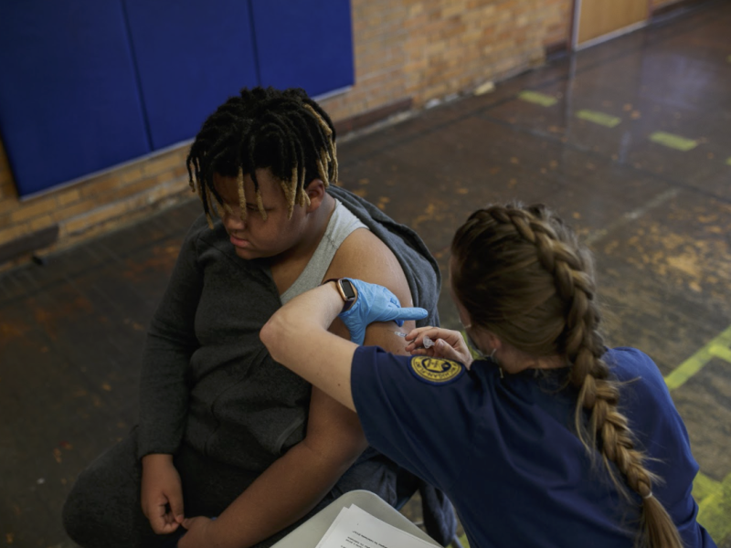 Troy Huddleston, 12, receives his second COVID-19 vaccine from Gabi Mundt, a Uof M Flint nursing student, at the Berston Field House Vaccine Clinic.