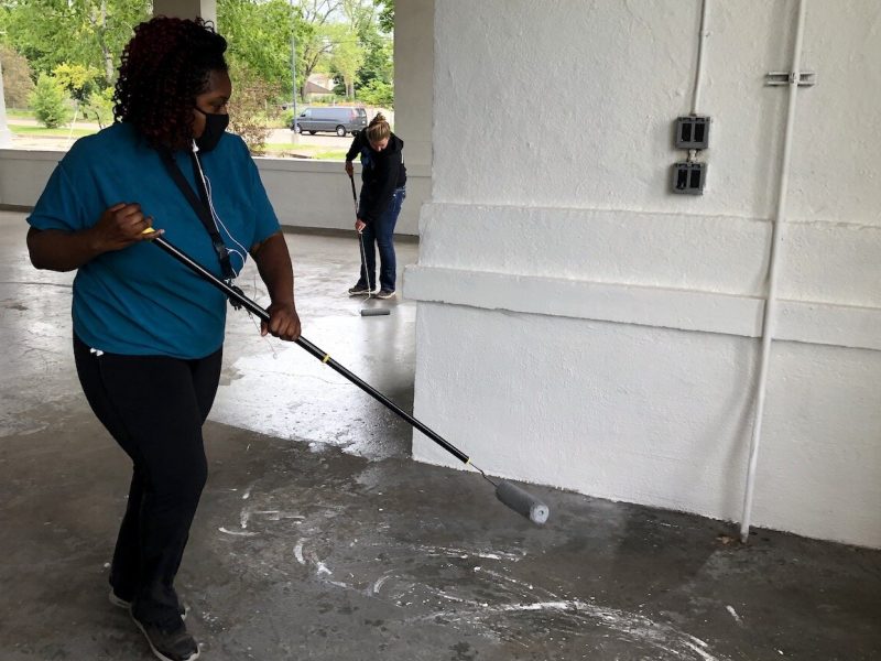 Ladel Lewis, second ward, and Allie Herkenroder, seventh ward, helped paint the floor at the Kearsley Park pavilion in May.