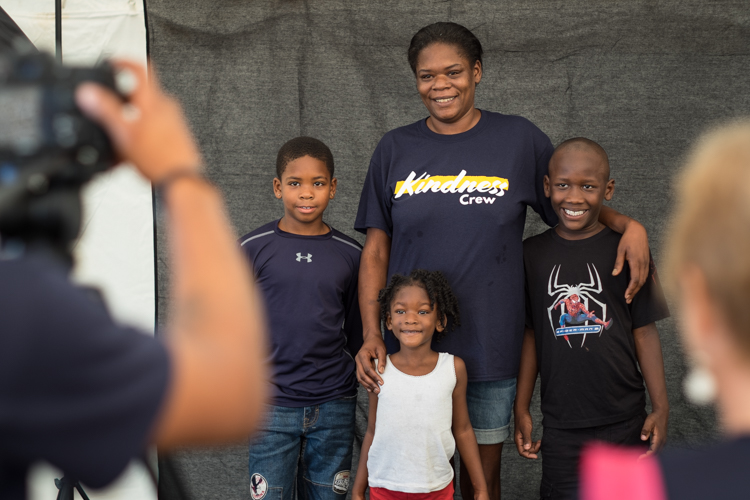 A family has a portrait taken at the Convoy of Hope event in Bassett Park in Flint on Saturday.