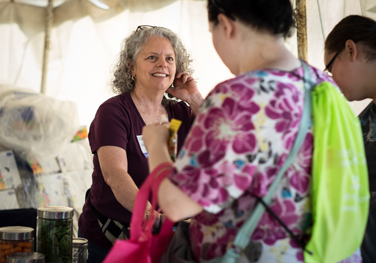 Holly Lubowicki of the Community Foundation of Greater Flint assists visitors to a tent assisting visitors with childhood nutrition at the Convoy of Hope event in Bassett Park in Flint on Saturday.