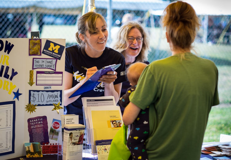 Researcher Erika Koeppe records a questionnaire for participant Courtney Schlachter of Flint. Koeppe asked questions dealing with family awareness of cancer at the Convoy of Hope event in Bassett Park in Flint on Saturday. In the background is Dr. El