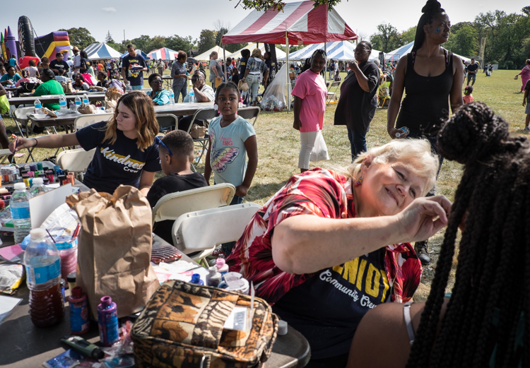Cyndie Martin of Flint paints faces at the Convoy of Hope event in Bassett Park in Flint on Saturday. She has a business called Unique Creations.