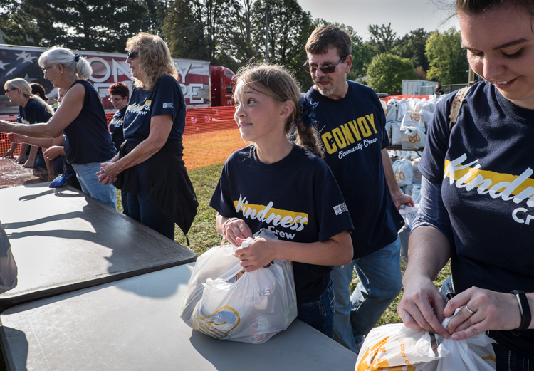 Bella Kirby, 11, of Goodrich, interacts with other volunteers at the Convoy of Hope event in Bassett Park in Flint on Saturday. She was working with the bagging of groceries effort. She attends Hillside Bible Church.