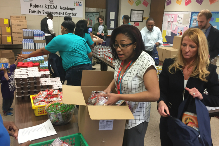Volunteers help stuff backpacks with food from the Food Bank of Eastern Michigan for Flint kids.