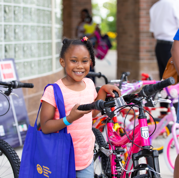 A young attendee wins a bike at one of Hamilton's family-friendly events during National Health Center Week.